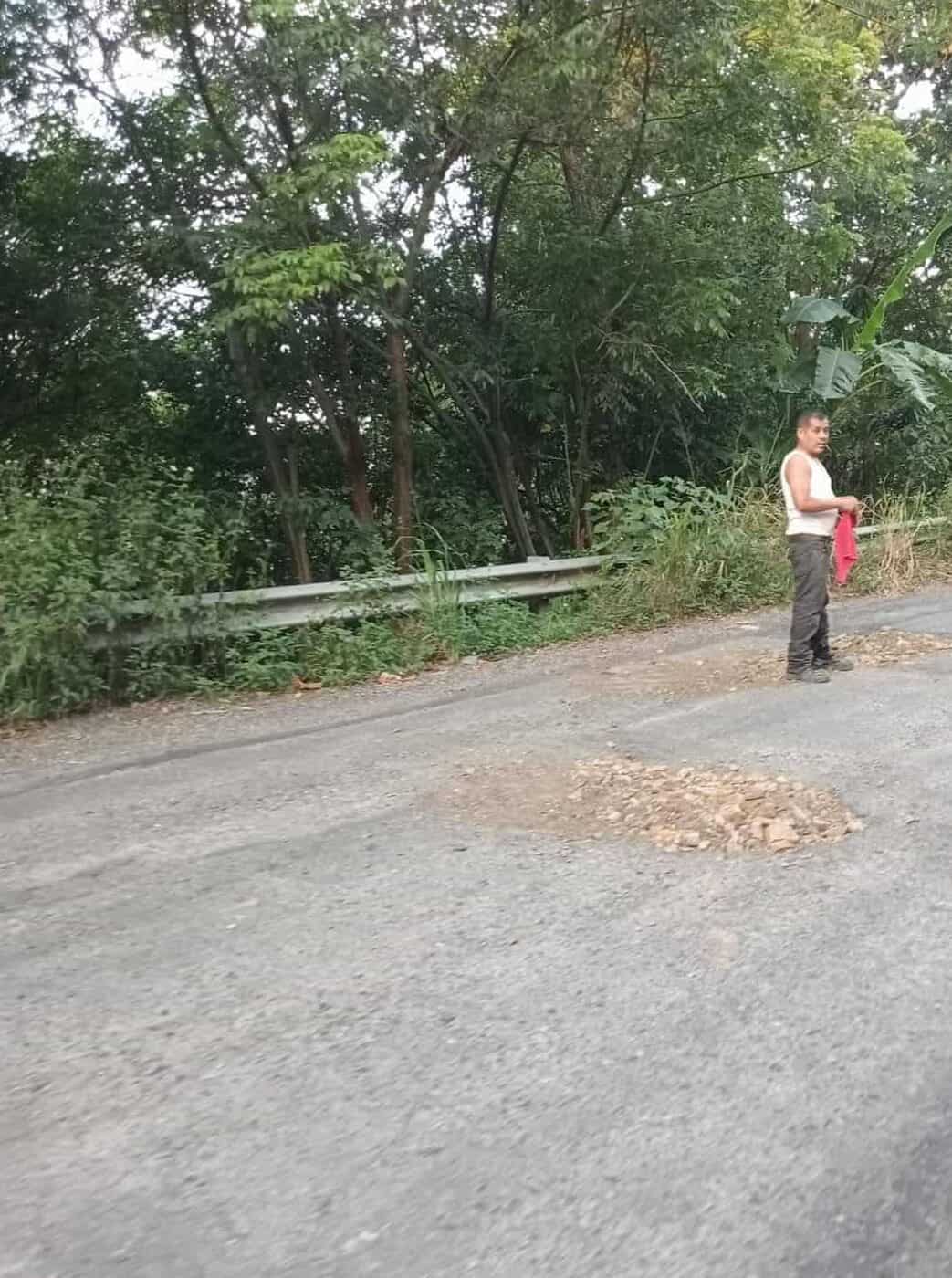 Transportistas toman la iniciativa y reparan baches en la carretera Huejutla-Tlanchinol